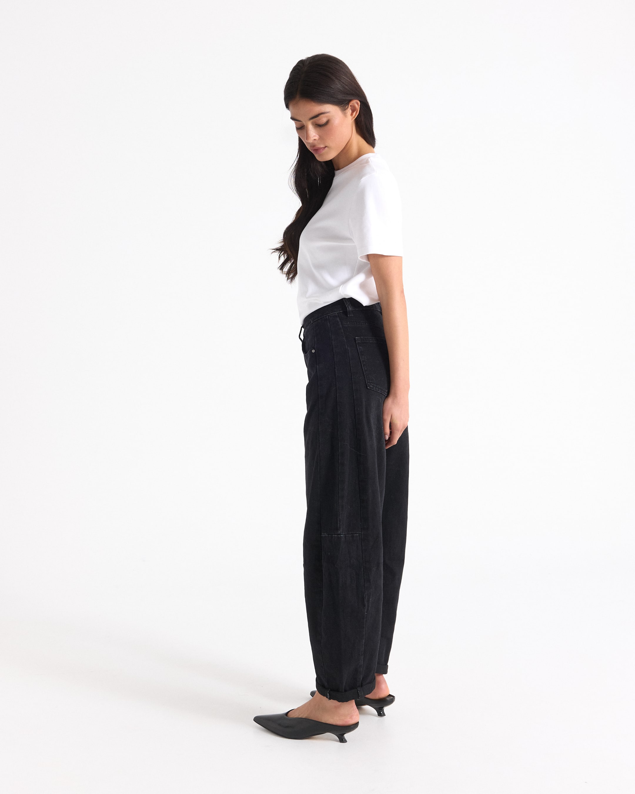 witte t-shirt, zwarte jeans, hoog taille, zijaanzicht, muilen